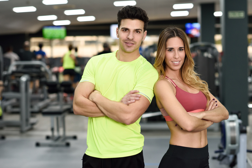 Man and woman personal trainers in the gym.