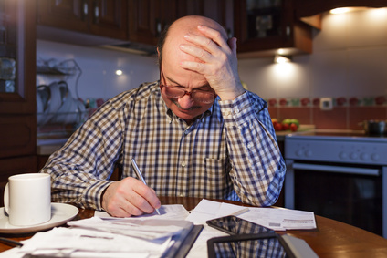 A man tiredly considers the family budget. Lack of money in the crisis.